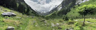 Blick auf eine grüne Landschaft mit Bergen und Wolken