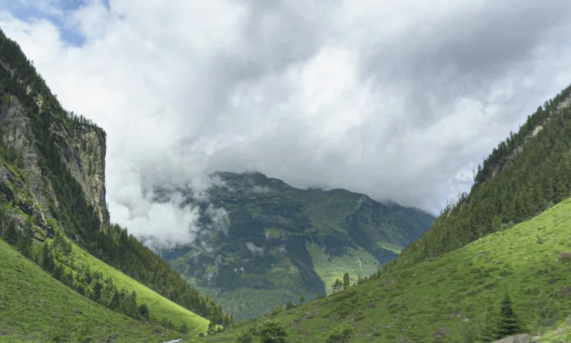 Blick auf eine grüne Schlucht mit Bergen und Wolken