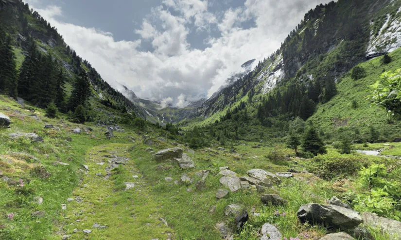 Berglandschaft mit grünen Wiesen und Wolken am Himmel